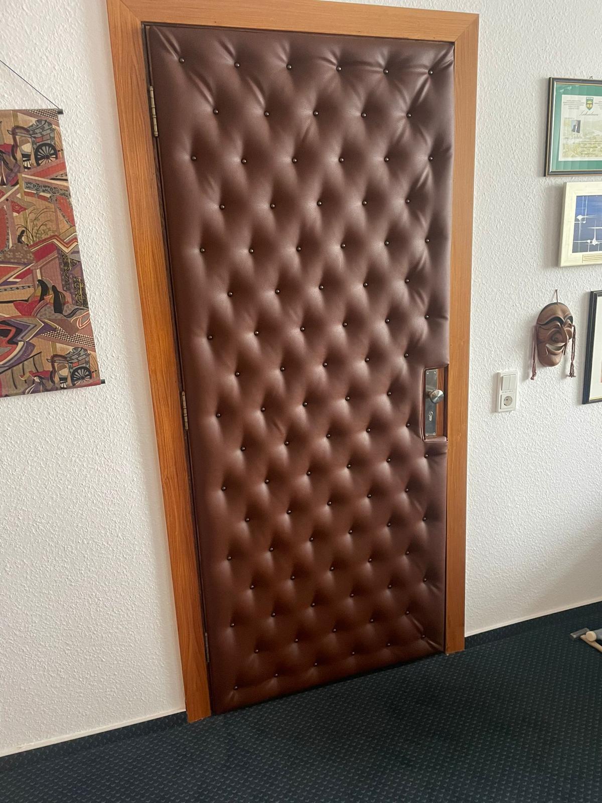 Zimmertür mit dunkelbraunem, geknöpftem Leder im Capitonné-Stil gepolstert